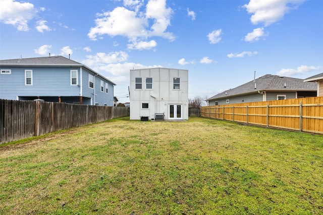 rear view of property with french doors, a yard, and central air condition unit