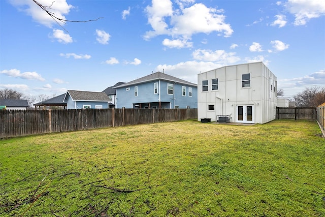 back of property featuring central AC unit, a lawn, and french doors