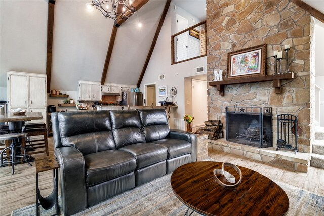 kitchen featuring light wood finished floors, tasteful backsplash, vaulted ceiling with beams, under cabinet range hood, and stainless steel electric range