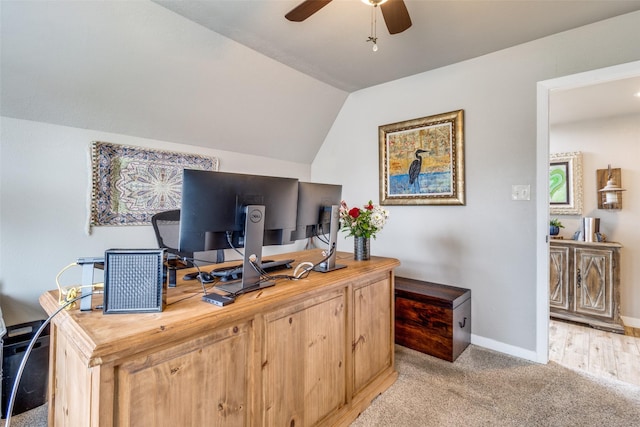 home office with lofted ceiling, light colored carpet, baseboards, and ceiling fan