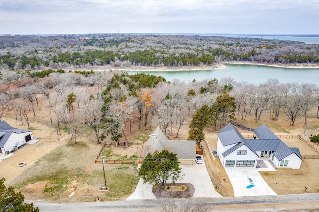 aerial view featuring a wooded view and a water view