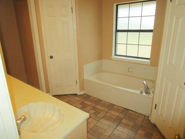 bathroom featuring vanity and a tub to relax in