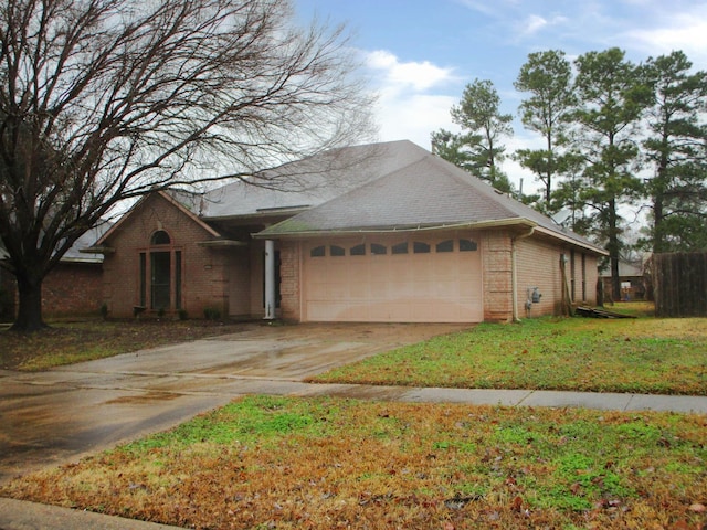 single story home featuring a garage and a front lawn