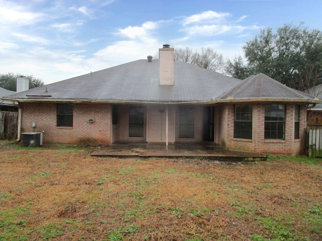 rear view of house with a yard, a patio, and central air condition unit