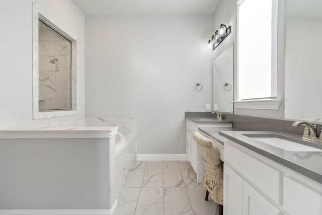 bathroom featuring vanity and tiled tub