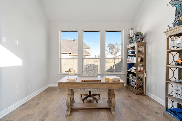 office featuring vaulted ceiling and light hardwood / wood-style flooring