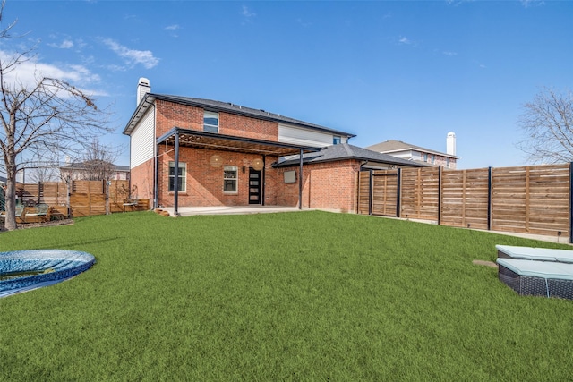 back of house with a yard and a patio