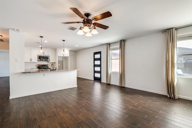 kitchen featuring light stone counters, white cabinetry, hanging light fixtures, kitchen peninsula, and stainless steel appliances