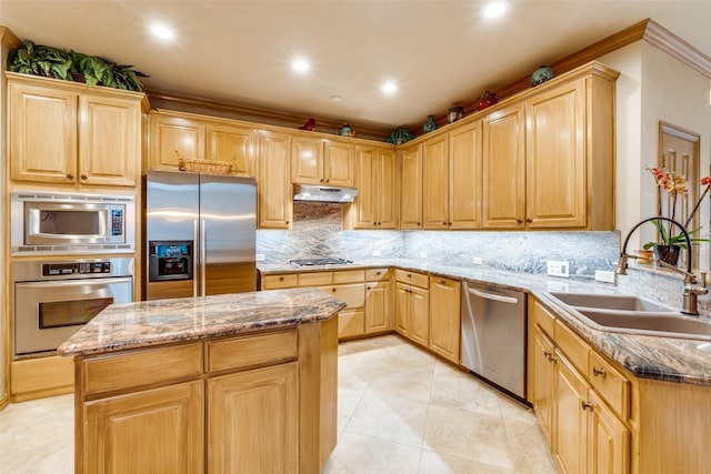 kitchen with a kitchen island, appliances with stainless steel finishes, sink, backsplash, and light stone counters