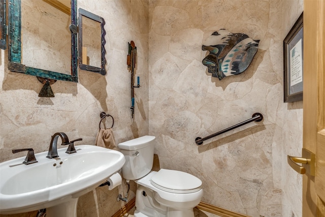 bathroom with tile walls, sink, and toilet