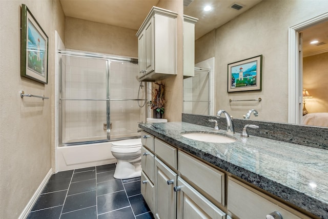 full bathroom with toilet, tile patterned floors, vanity, and bath / shower combo with glass door