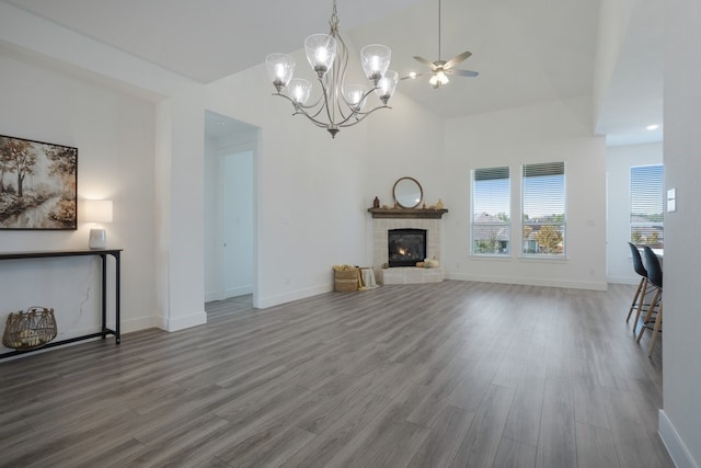 unfurnished living room featuring a tiled fireplace, hardwood / wood-style flooring, high vaulted ceiling, and ceiling fan