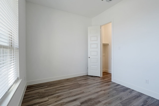 empty room featuring dark wood-type flooring and a wealth of natural light