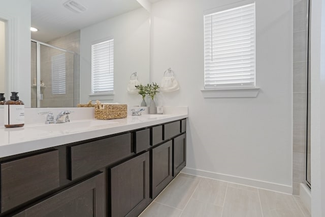 bathroom with an enclosed shower, vanity, and tile patterned flooring