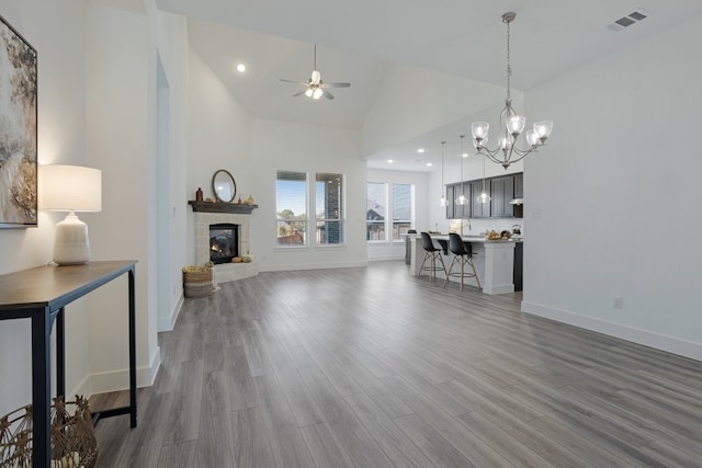 living room with hardwood / wood-style flooring, high vaulted ceiling, and ceiling fan