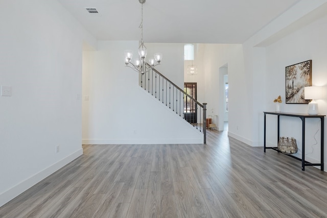 unfurnished living room with light hardwood / wood-style flooring and a chandelier