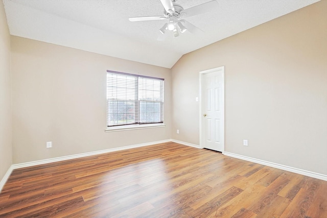 empty room with vaulted ceiling, ceiling fan, and light hardwood / wood-style floors