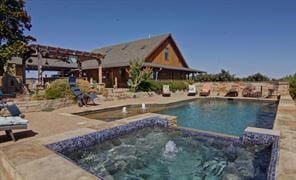 view of pool with an in ground hot tub