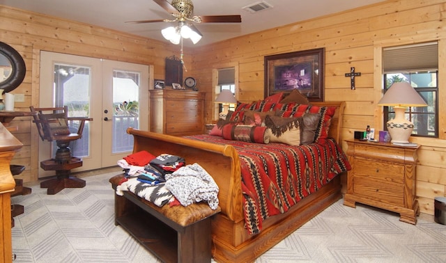 bedroom featuring light carpet, access to outside, french doors, and wooden walls