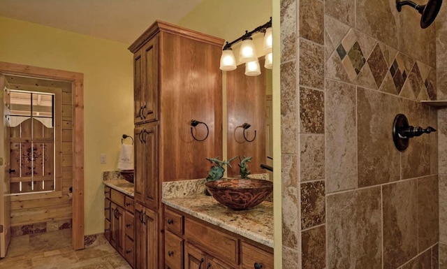 bathroom with vanity and a tile shower