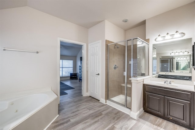 bathroom with vanity, lofted ceiling, shower with separate bathtub, and hardwood / wood-style floors