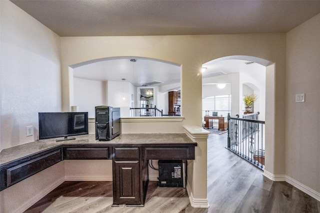 kitchen with dark brown cabinetry and light hardwood / wood-style flooring