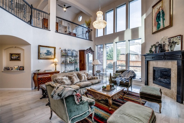 living room featuring an inviting chandelier, a fireplace, and light wood-type flooring