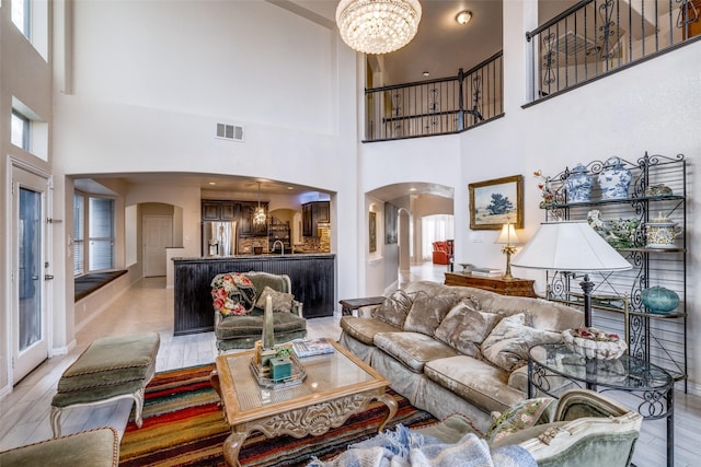 living room with light wood-type flooring, a wealth of natural light, and a chandelier