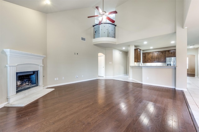 unfurnished living room featuring light hardwood / wood-style flooring, ceiling fan, and vaulted ceiling