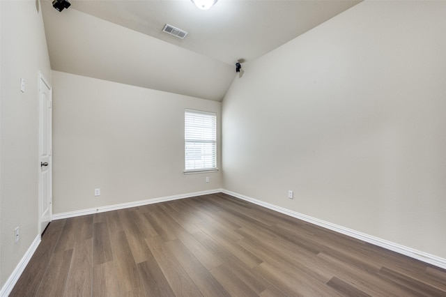 spare room with hardwood / wood-style flooring and lofted ceiling