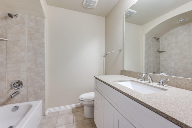 full bathroom with tiled shower / bath, vanity, tile patterned floors, and toilet