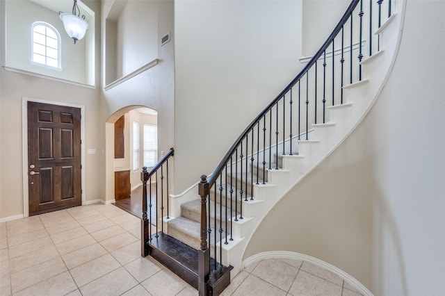 entrance foyer with light tile patterned floors and a high ceiling