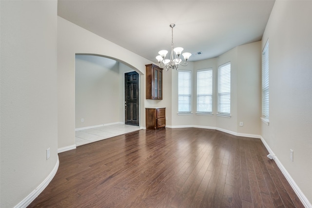 unfurnished living room with a notable chandelier and wood-type flooring