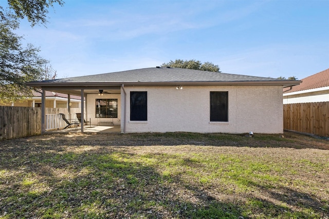 rear view of house with a patio, ceiling fan, and a lawn