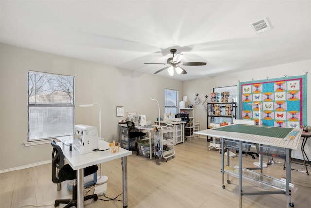 home office with ceiling fan and light hardwood / wood-style flooring