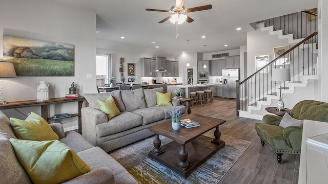 living room featuring ceiling fan and dark hardwood / wood-style flooring