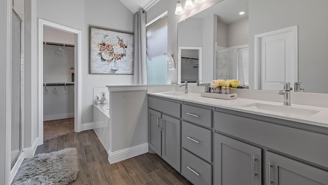 bathroom with hardwood / wood-style flooring, vanity, vaulted ceiling, and shower with separate bathtub