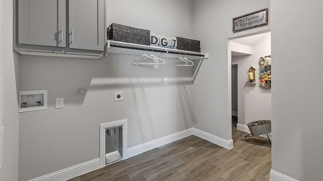 washroom with gas dryer hookup, cabinets, washer hookup, hookup for an electric dryer, and hardwood / wood-style floors