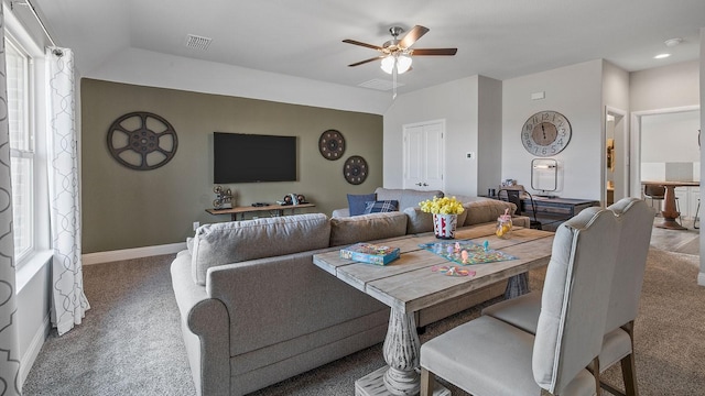 carpeted dining room with ceiling fan and vaulted ceiling