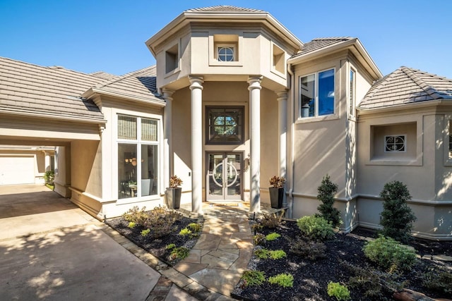 doorway to property with a garage and a carport