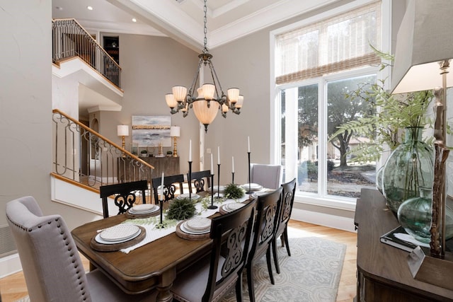 dining area featuring crown molding, a wealth of natural light, a notable chandelier, and light wood-type flooring