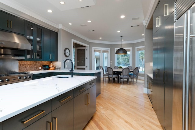 kitchen featuring crown molding, sink, decorative light fixtures, and extractor fan