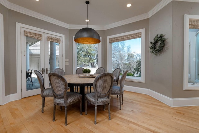 dining space featuring crown molding, french doors, and light wood-type flooring