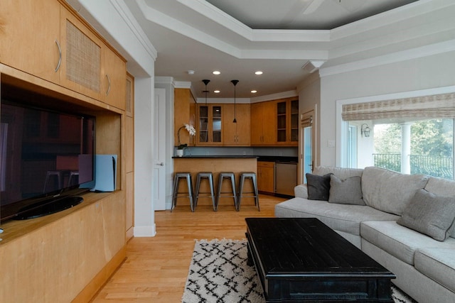 living room with crown molding, a raised ceiling, and light hardwood / wood-style flooring