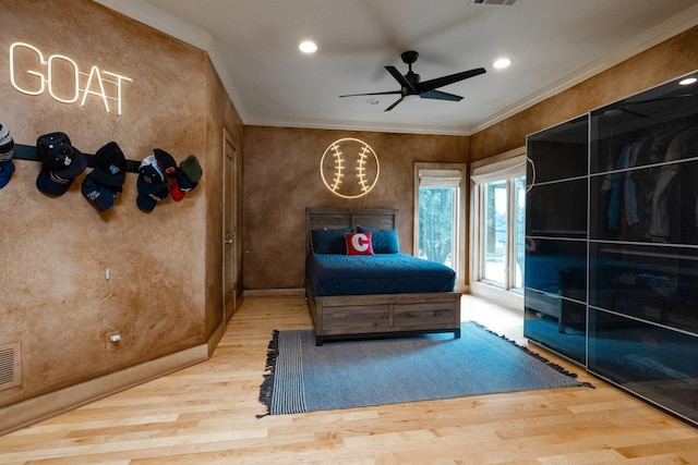 bedroom with ornamental molding, hardwood / wood-style floors, and ceiling fan