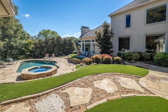 view of pool with an in ground hot tub, a patio area, and a lawn