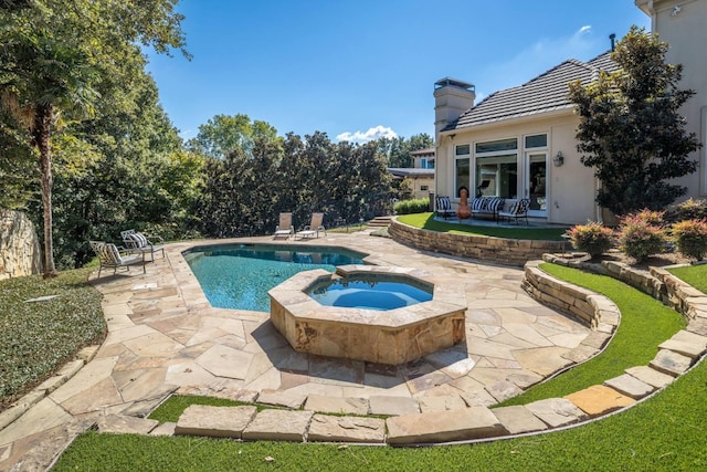 view of swimming pool featuring an in ground hot tub and a patio area