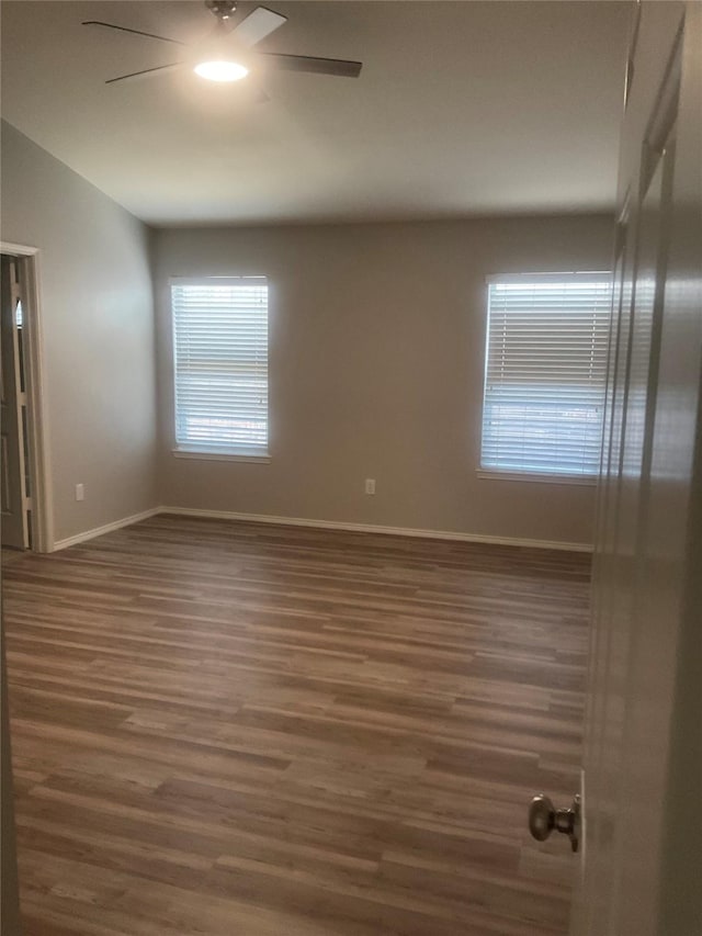 unfurnished room with ceiling fan and dark hardwood / wood-style floors