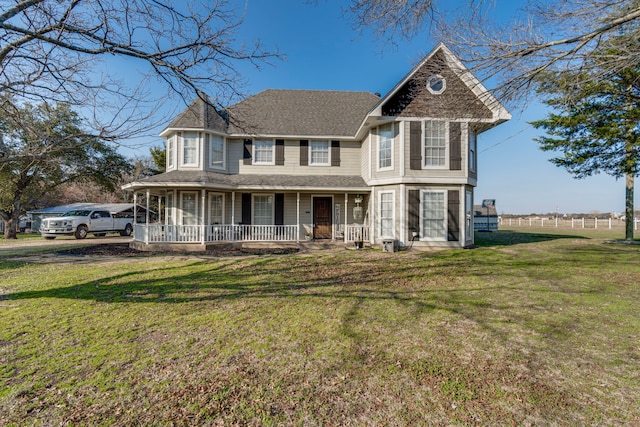 victorian-style house featuring covered porch and a front lawn