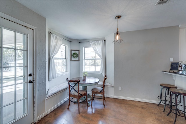 dining room with visible vents, concrete floors, breakfast area, and baseboards